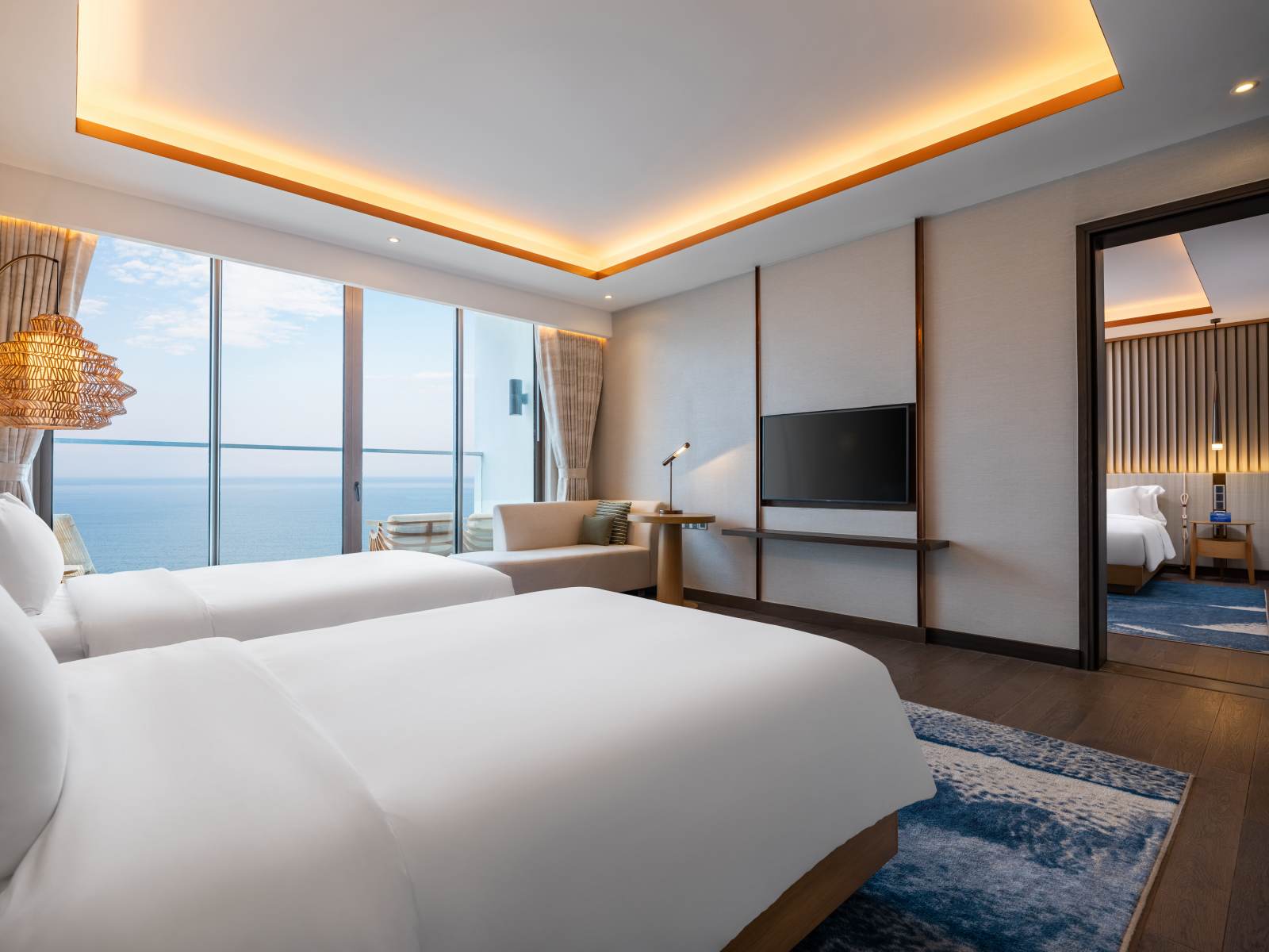 A room with two beds and a televisionDescription automatically generated